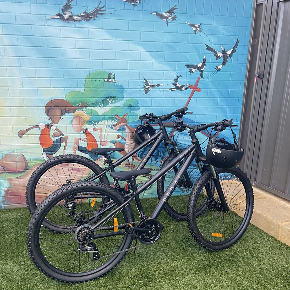 Two bicycles parked outside a painted mural