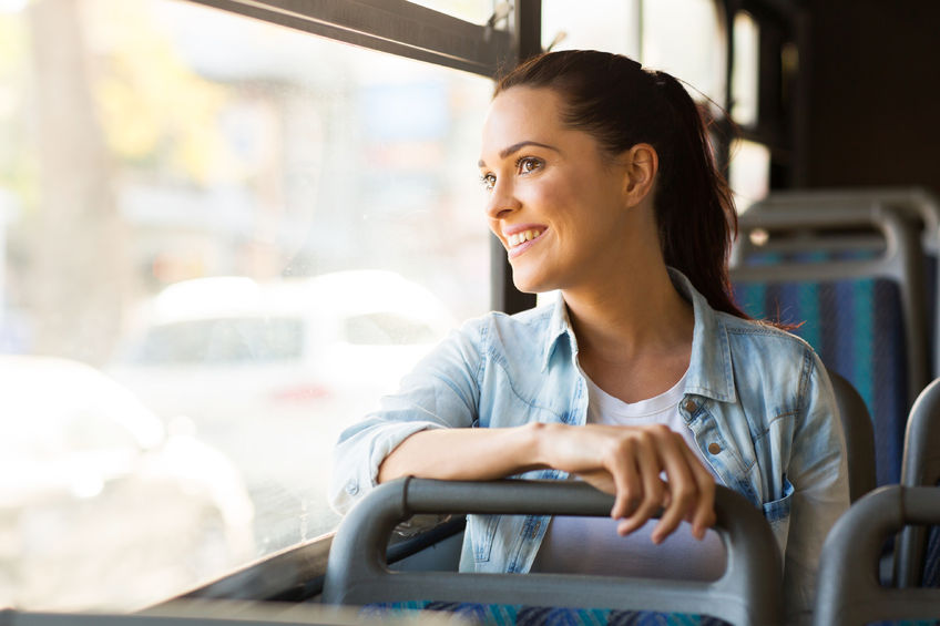 Woman smiling looking out of bus window